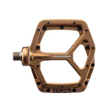Bronze Race Face Atlas mountain bike pedal with topographic design, featuring durable aluminum construction and multiple grip pins for trail riding.