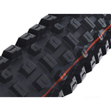 Mountain bike tire with aggressive tread pattern and red sidewall stripe for off-road performance