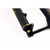 Black mountain bike suspension fork with yellow adjustment labels and fast/slow settings