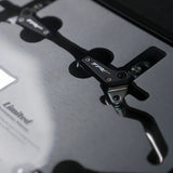 Close-up of TRP brand bike brake components resting on a metallic surface.